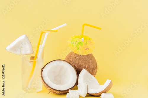 Fresh Coconut cocktail with a straws on yellow background