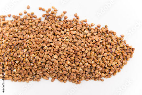 buckwheat groats scattered on white background