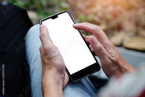 Mock up smartphone of hand holding black mobile phone with blank white screen	