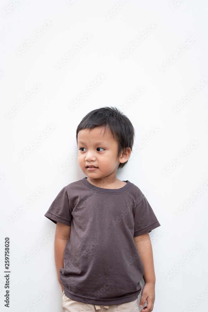 Portrait of a toddler boy wearing grey T-shirt with a little smile on white background Portrait of a toddler boy wearing grey T-shirt with a little smile on white background
