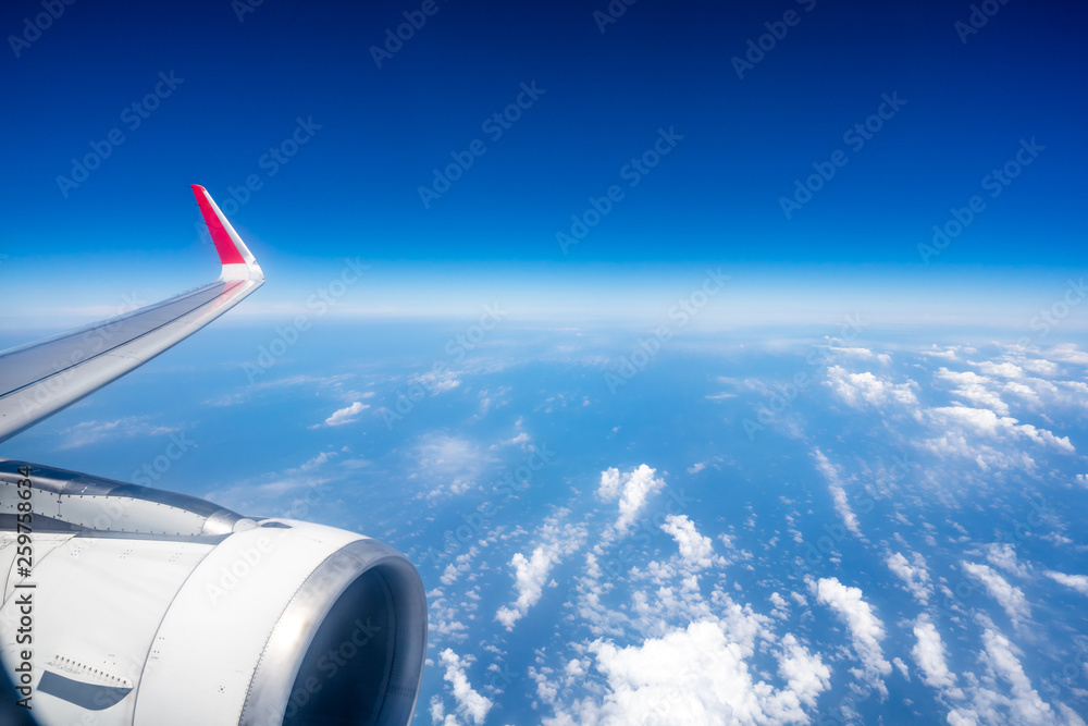 Fototapeta premium wing of airplane flying above clouds