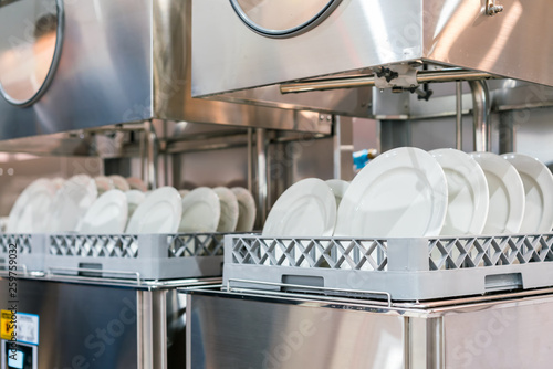 close up white plate on basket in automatic dishwasher machine for industrial photo