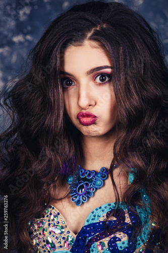 Close-up portrait of a beautiful attractive model with voluminous hairstyle and professional make-up.