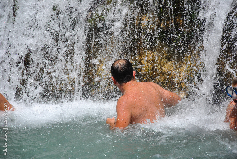 Hombre bajo una catarata dentro del río Hombre bajo una catarata dentro del río