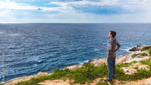Man stands on the edge of the abyss and looks at the sea