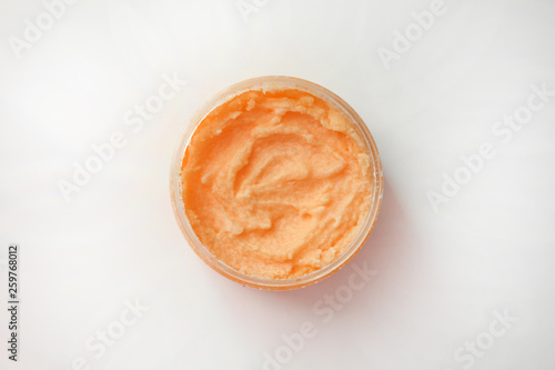 Container with natural scrub on white background. Top view.Copy space.