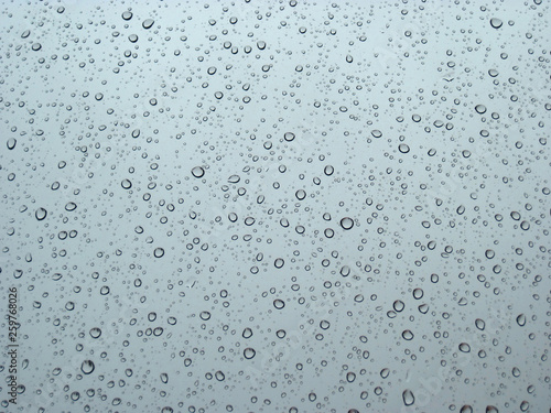 Raindrops on the window glass in opposite light