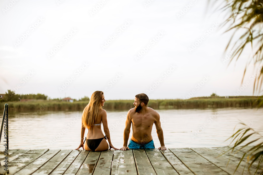 Sensual romantic couple in love on pier at the lake outdoor in summer day