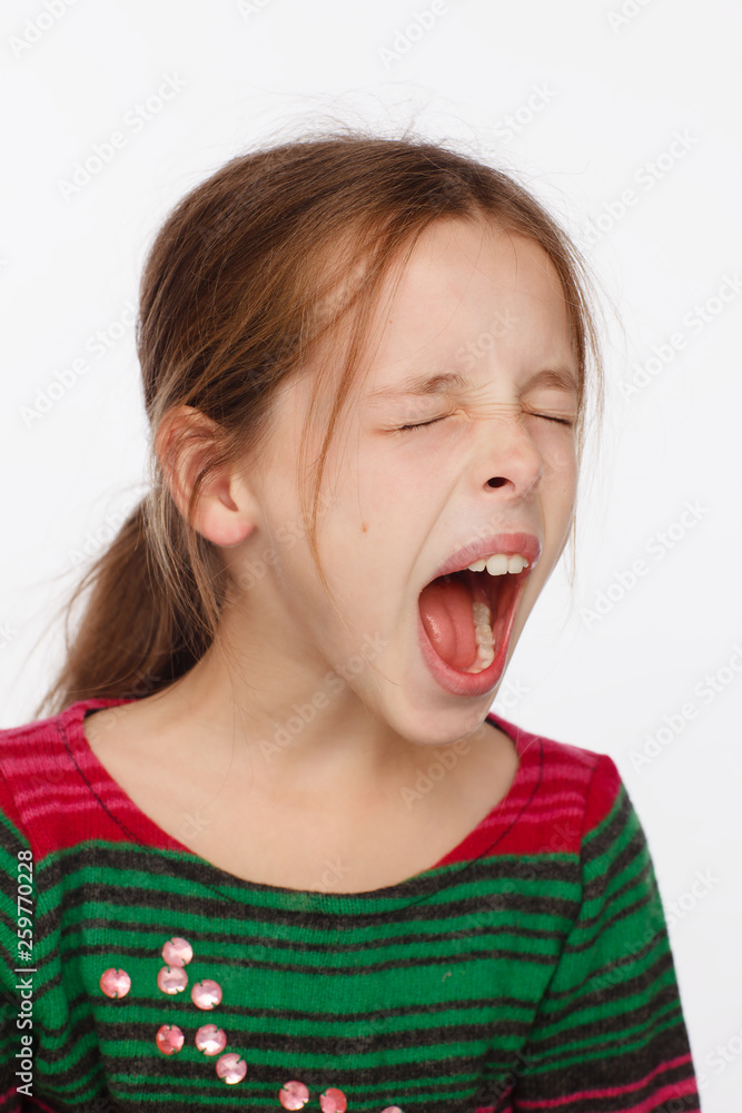 Portrait of a screaming 8-year-old girl in a sweater in crimson and green stripes Portrait of a screaming 8-year-old girl in a sweater in crimson and green stripes