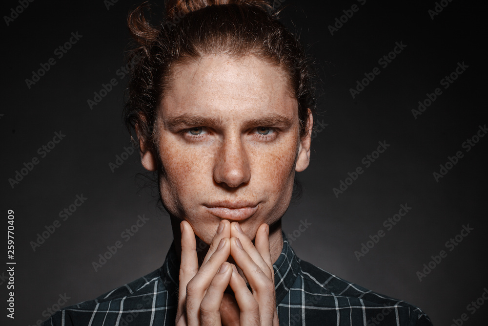 Portrait of a man with drawn hair and freckles, dressed in a checkered shirt Portrait of a man with drawn hair and freckles, dressed in a checkered shirt
