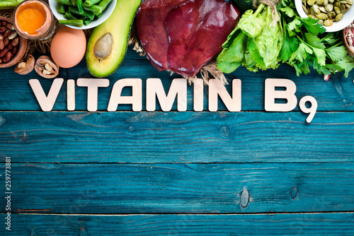 Cuadro en lienzo Foods that contain natural vitamin B9: Liver, avocado, broccoli, spinach, parsley, beans, nuts, on a blue background