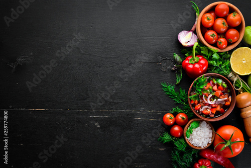 salsa sauce and ingredients. Latin American Mexican Traditional Sauce. Top view. On a black background. Free space for text.