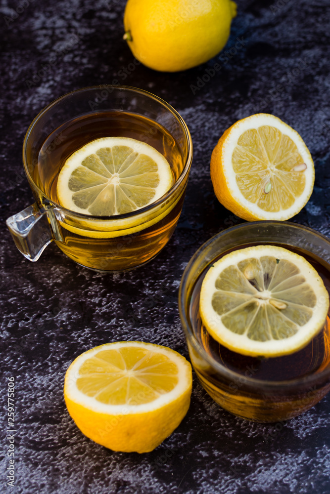 A cup of tea and lemon on a dark background. Top view A cup of tea and lemon on a dark background. Top view