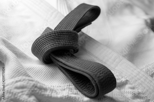 Black martial arts belt tied in a knot with white kimono in background
