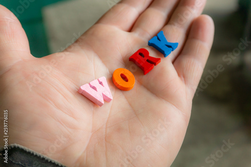 Wallpaper Mural Multi-colored letters word work on a man's hand. Torontodigital.ca