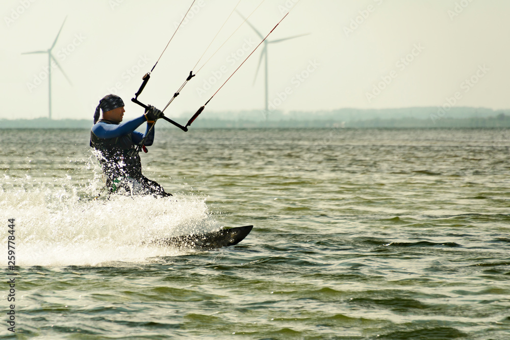 Kitesurfing Kiteboarding action photos man among waves quickly goes