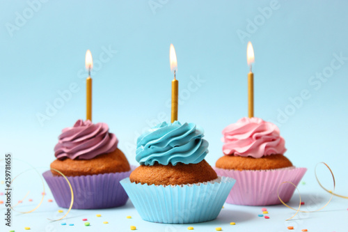Delicious cupcakes with candles on a colored background. Festive background, birthday