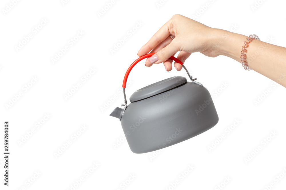 Woman hand pouring tea from steel teapot isolated on white Woman hand pouring tea from steel teapot isolated on white