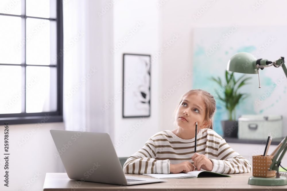 Pretty preteen girl doing homework at table in room Pretty preteen girl doing homework at table in room