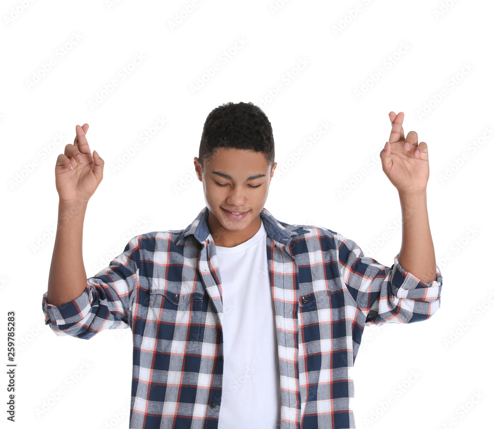 African-American teenage boy crossing his fingers on white background African-American teenage boy crossing his fingers on white background