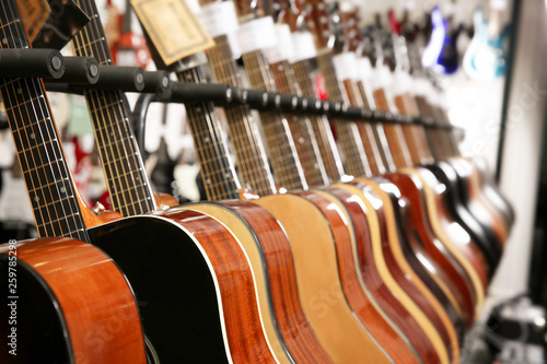 Row of different guitars in music store, closeup