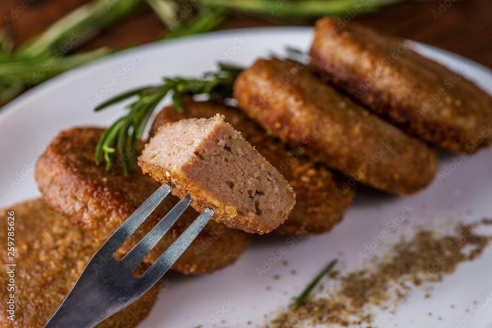 piece of cut cutlet stuffed on a fork with vegetables and greens on the background piece of cut cutlet stuffed on a fork with vegetables and greens on the background