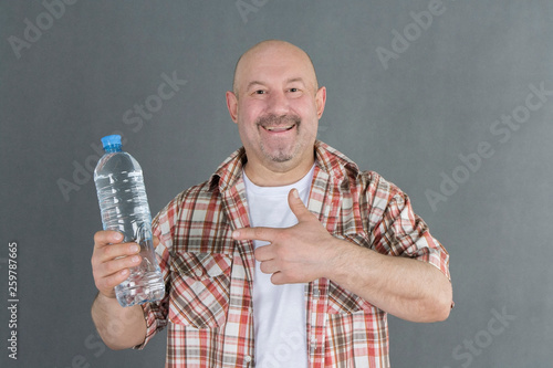 bald man with a bottle of water in his hands
