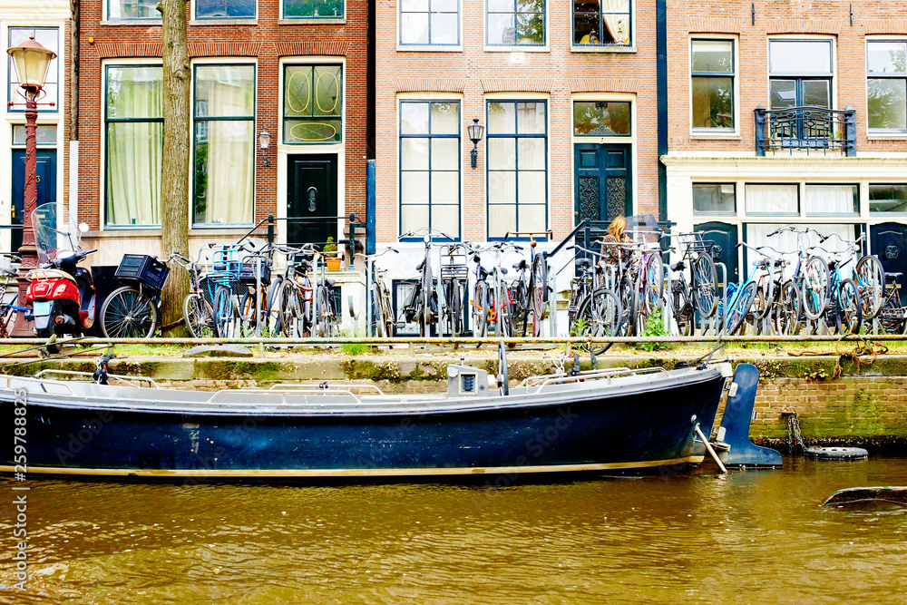 Bicycles parked on street in Amsterdam in rainy day, The Netherlands