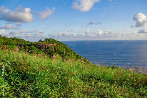 paragliding hill watugupit at yogyakarta, beautiful view of hill and sea with blue sky and clouds photo