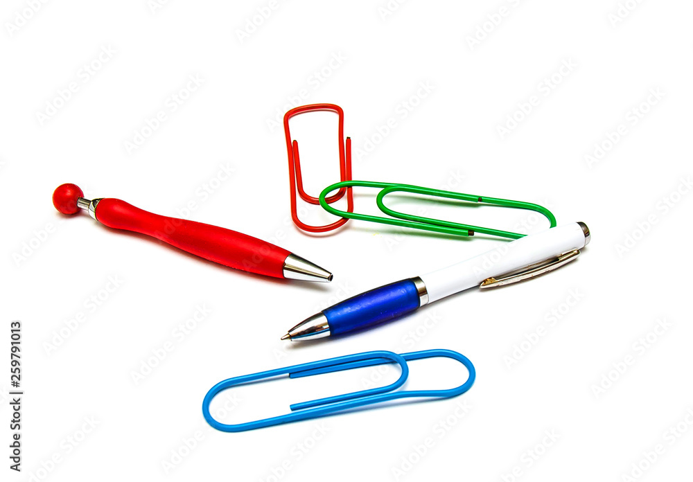 Large multi-colored paper clips and ballpoint pens on a white background the concept of stationery Large multi-colored paper clips and ballpoint pens on a white background the concept of stationery
