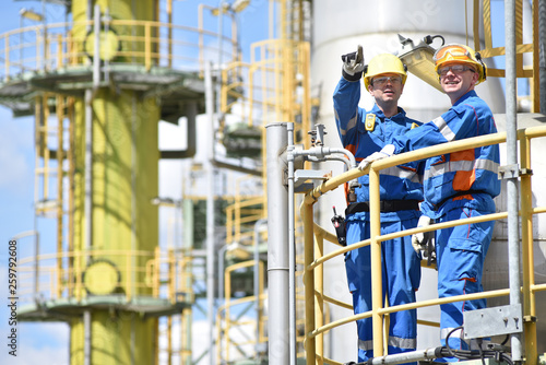 Arbeiter in der Industrie in einer Raffinerie - Teamwork // teamwork: group of industrial workers in a refinery - oil processing equipment and machinery photo