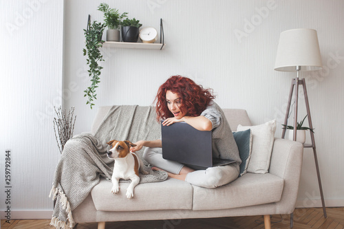 Young woman playing with her pet. Female and her dog indoor. An owner and his pet at home having fun. Woman training jack russel terrier to execute commands. © olenachukhil
