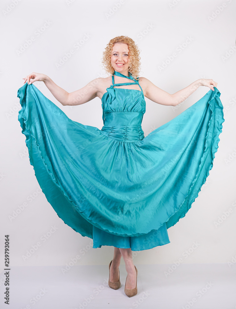slim airy girl in flying blue evening dress on white background in Studio slim airy girl in flying blue evening dress on white background in Studio