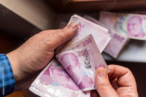 man counting 200 turkish lira banknote
