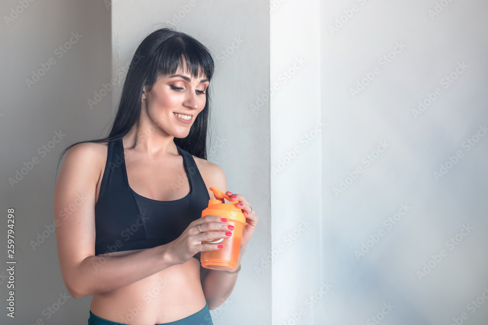 Fitness girl in the gym with a bottle of water