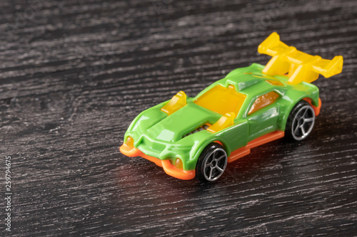 Yellow and green car toy on a dark wooden table