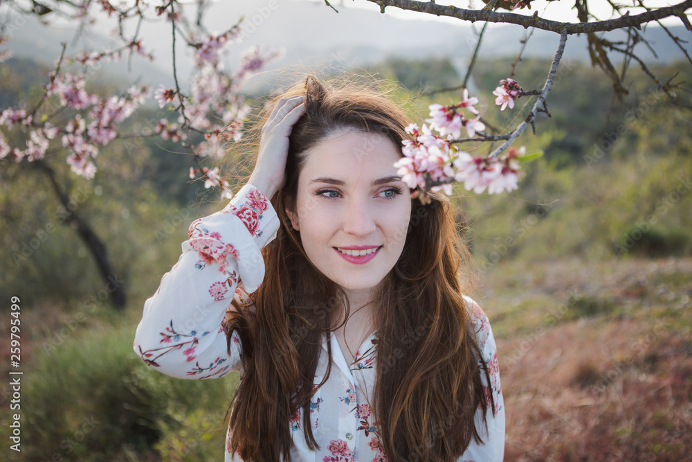 © Carla Gomez/ADDICTIVE STOCK - View through twigs of blooming wood of attractive cheerful lady looking away in garden between hills © Carla Gomez/ADDICTIVE STOCK - View through twigs of blooming wood of attractive cheerful lady looking away in garden between hills