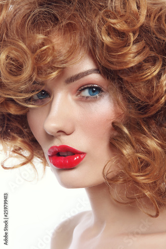 Young beautiful woman with curly hair and red lipstick