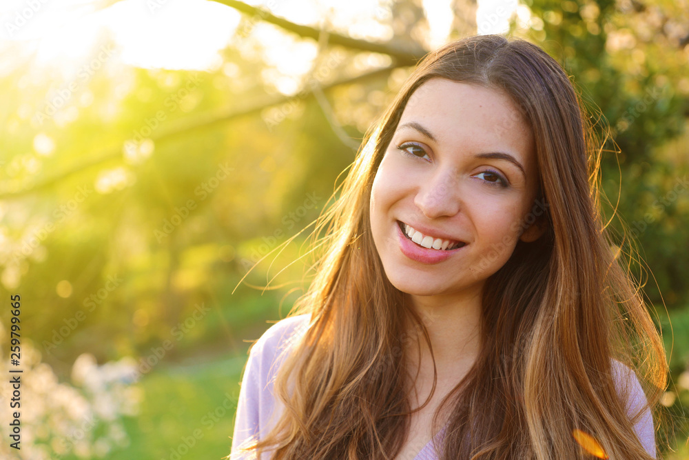 Portrait of happy smiling woman standing on sunny summer or spring day outside, cute smiling woman looking at you, attractive young girl enjoying summer, filtered image, flare sunshine. Portrait of happy smiling woman standing on sunny summer or spring day outside, cute smiling woman looking at you, attractive young girl enjoying summer, filtered image, flare sunshine.