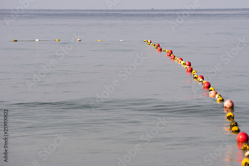 swimming area in the sea fenced with buoys