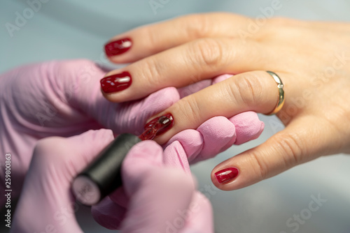do manicure, nail red lacquer close-up