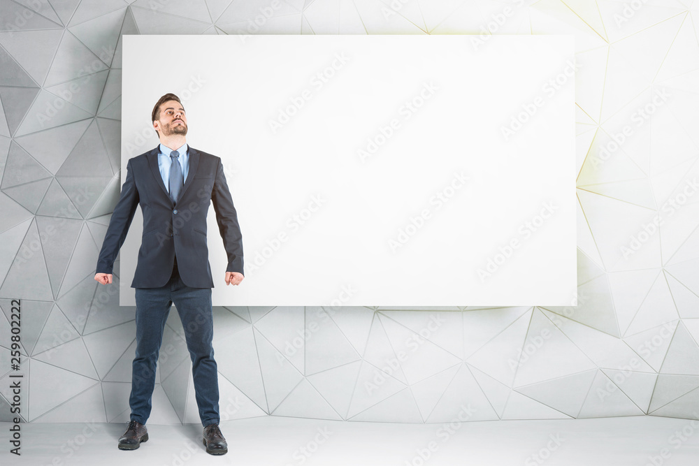 Successful businessman near mock up poster Successful businessman near mock up poster