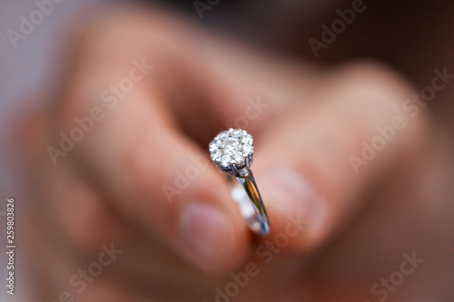 Close-up of a ring in a mans hand. young man giving engagement ring to his girlfriend. Man making marriage proposal to his beloved woman. Romantic date. photo