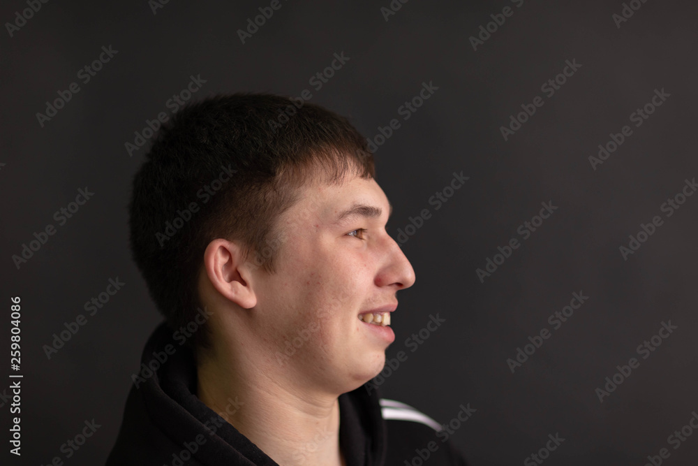 a young man in a black hoodie against a dark background a young man in a black hoodie against a dark background