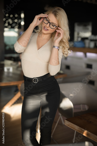 Sexy beautiful woman with eyeglass posing in cafe like a model