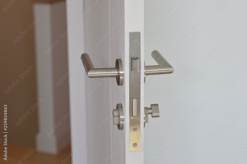 Handle stainless steel door on white wooden doors, silver color of door handle.