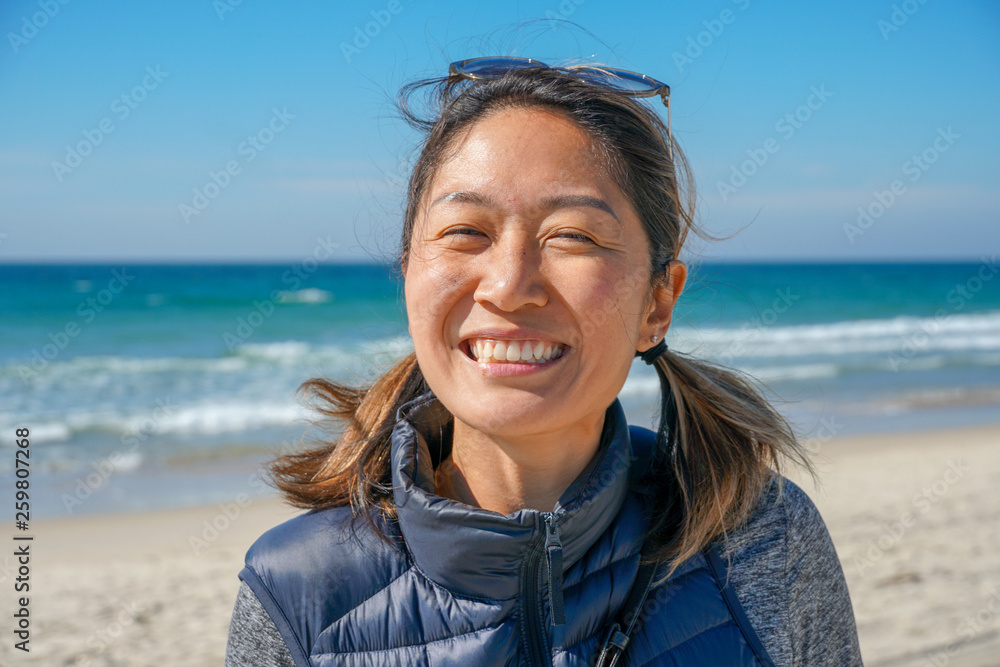 Portrait of smiling young Asia sporty woman at the beach during summer day. Beautiful girl smiling. inspiring moment. Portrait of smiling young Asia sporty woman at the beach during summer day. Beautiful girl smiling. inspiring moment.