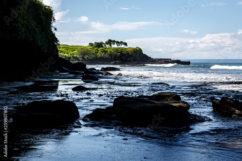 Volcanic coast with rocks and black sand on Bali, Indonesia photo