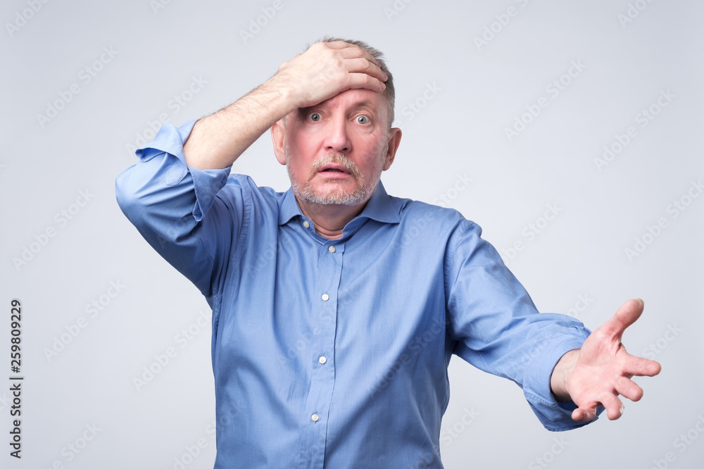 Naklejka premium Senior caucasian man surprised with hand on head.