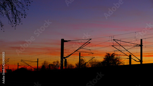 Bahngleise, Oberleitungen, Silhouette mit Bäumen, im Sonnenuntergang 